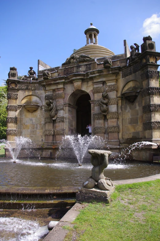 a view of an outdoor fountain, with two men standing in the distance