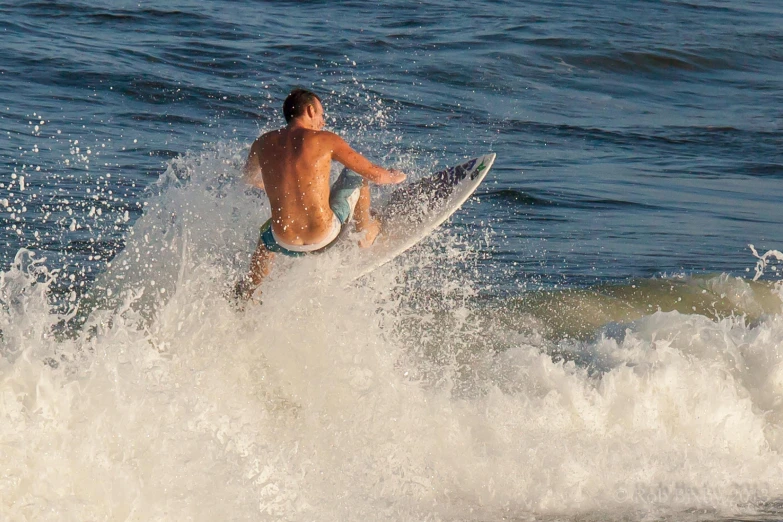 a man in blue trunks riding a surfboard