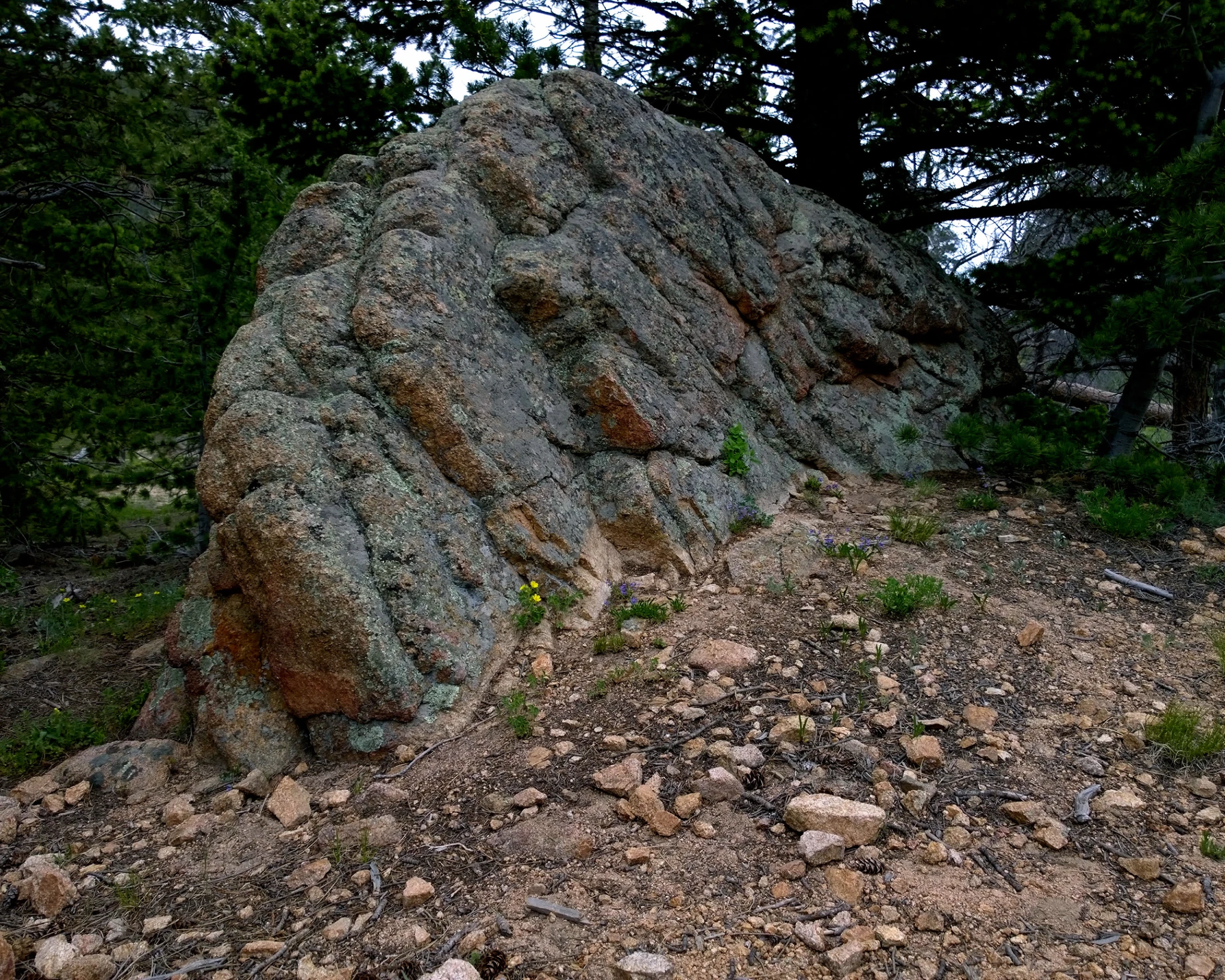 a large rock formation with many small rocks around it