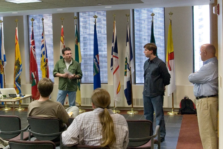 people are talking in front of flags in an event