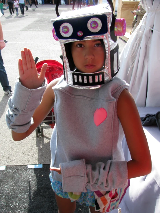 a little girl in a robot costume is waving