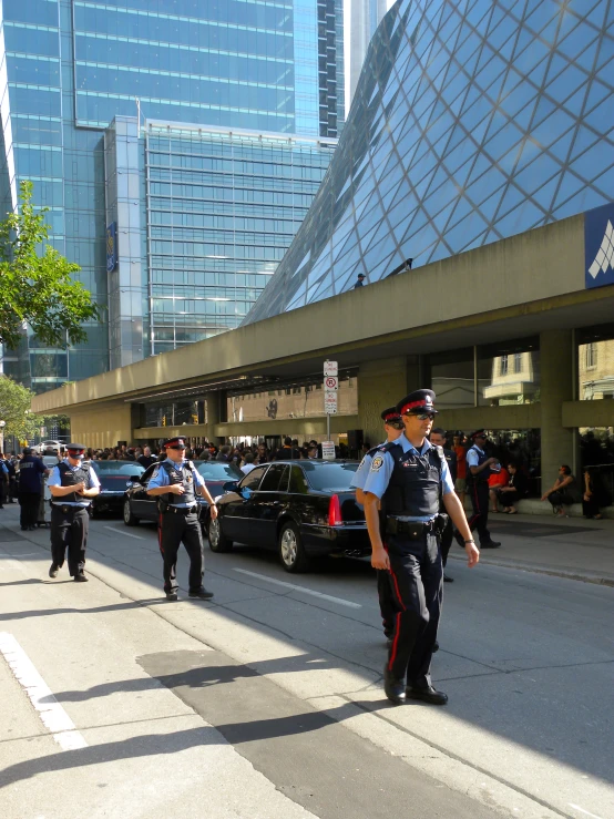 three uniformed cops are patrolling a city street