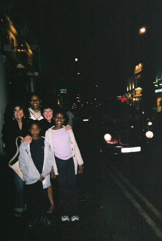 people taking a picture at night on the street