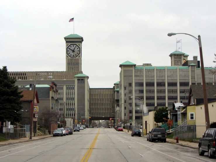 a clock tower stands between two buildings in a city