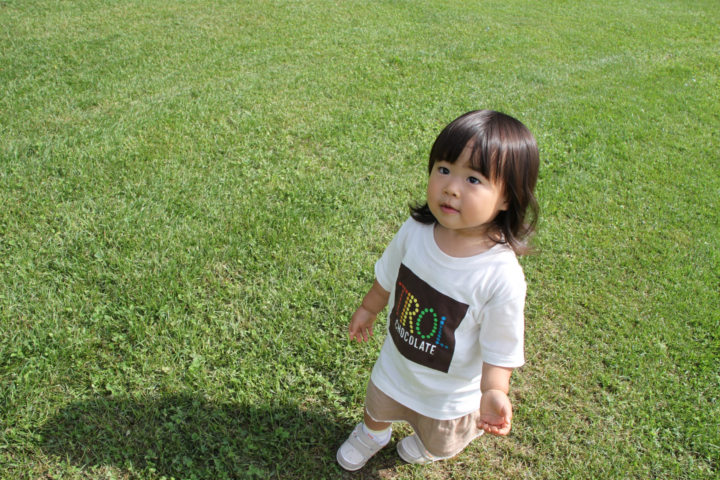 a little girl that is standing in the grass