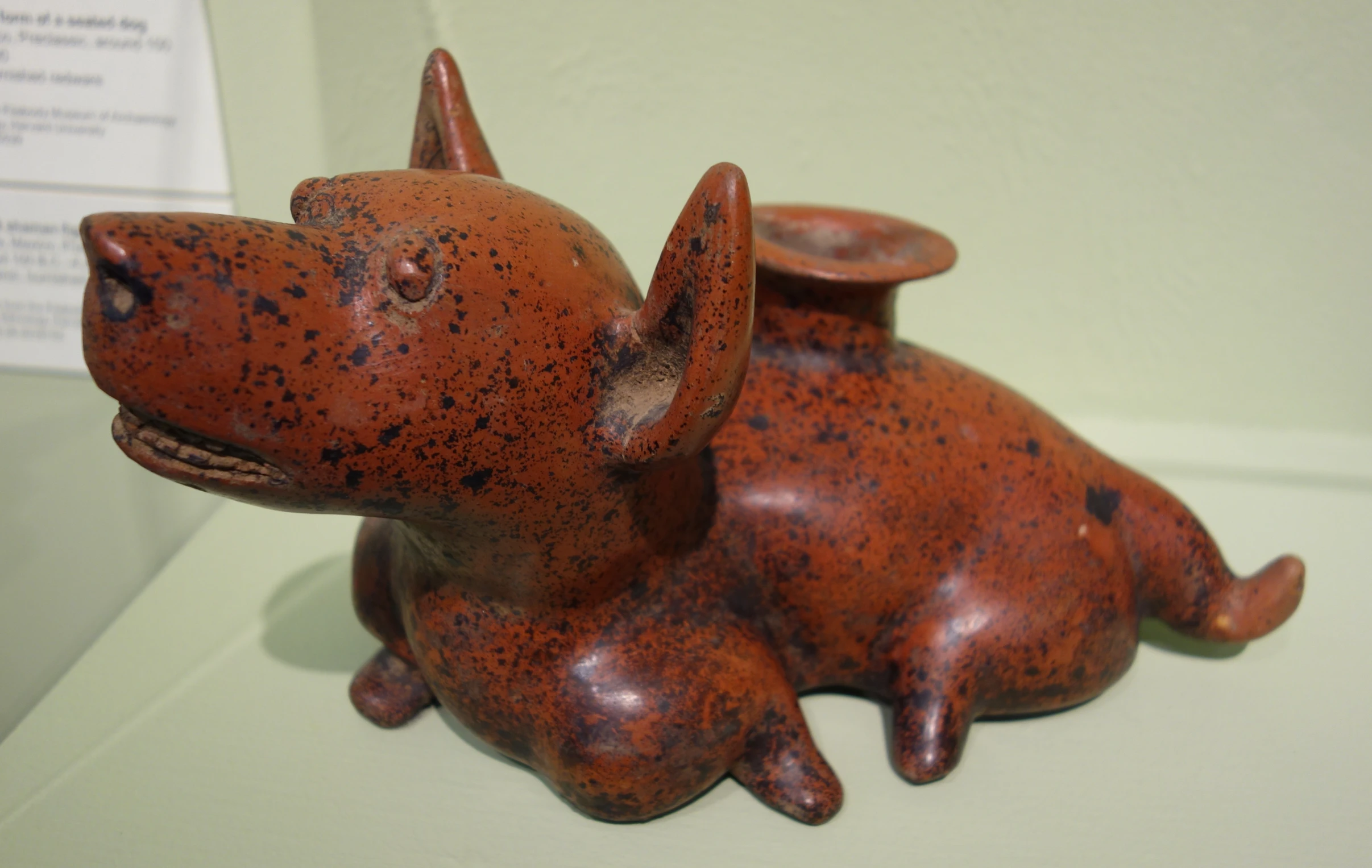 a ceramic dog sitting down on a white surface