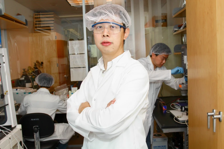 a woman wearing a white coat standing in front of a counter top oven