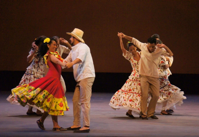 dancers in various traditional dress dancing on a stage