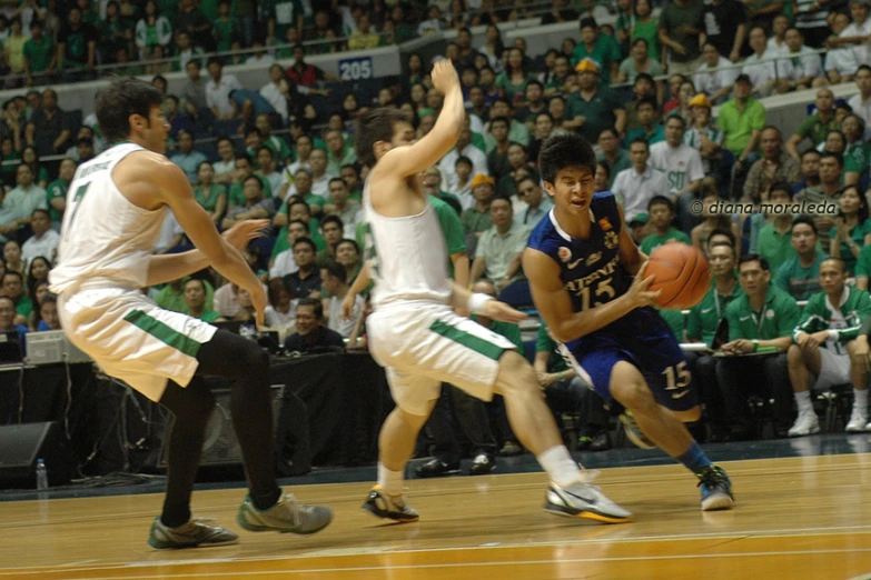 several basketball players playing on a court surrounded by spectators