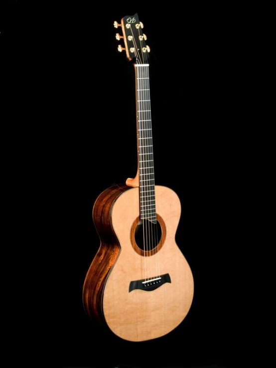 an acoustic guitar sits against a black background