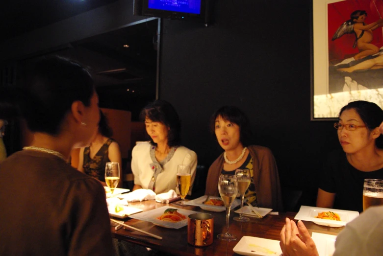 four women seated at a wooden table in a restaurant