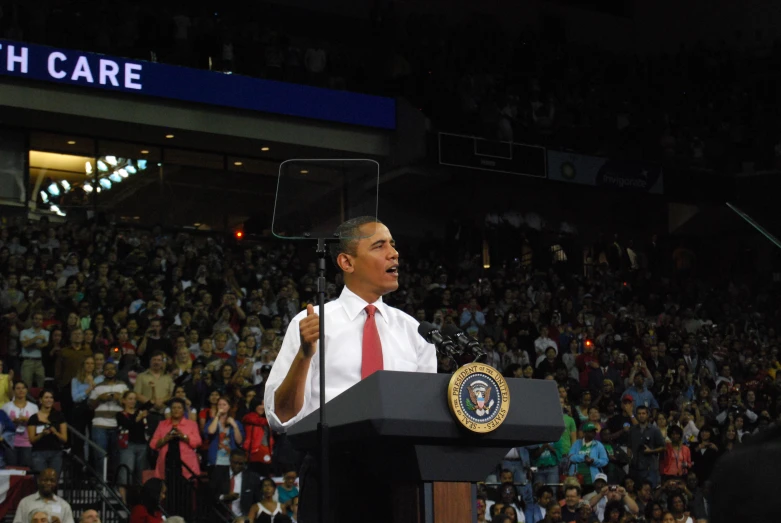 a man in a suit and tie standing in front of a podium