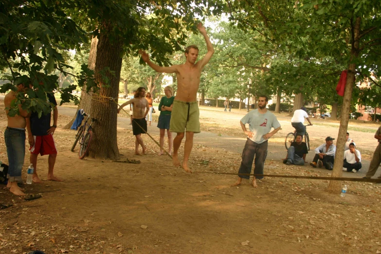 a group of people stand around in the dirt and talk