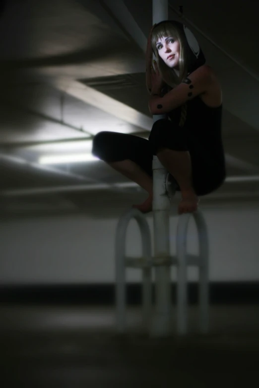 a woman on top of the pole in a room