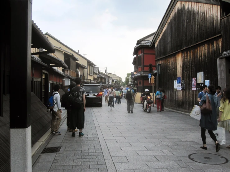 people walk on a sidewalk in the old town