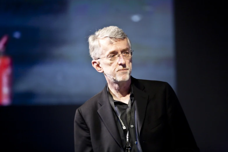 a man in a black jacket standing up