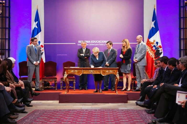 people watching two men on the stage and one woman and two men standing