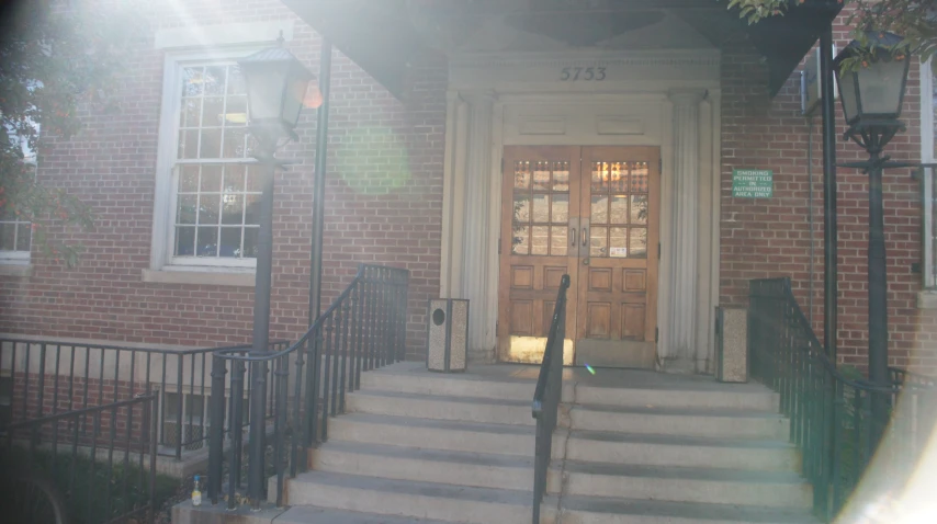 a door is open at a brick building with stairs