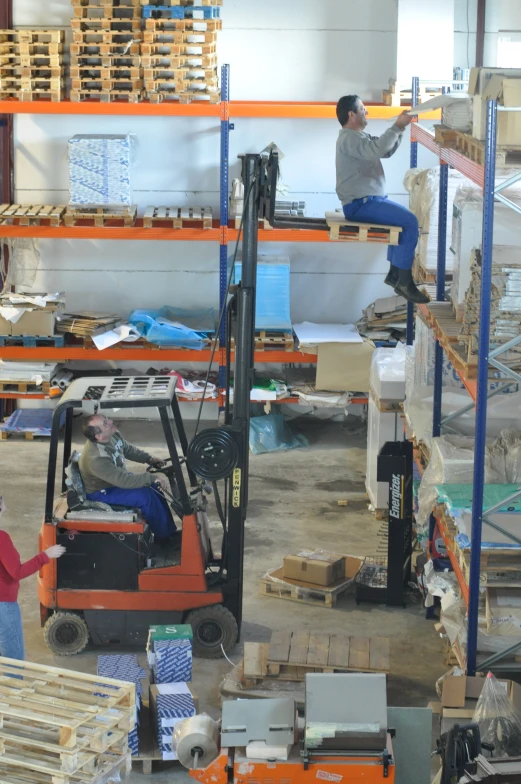 two men working in a warehouse as others shop the shelves