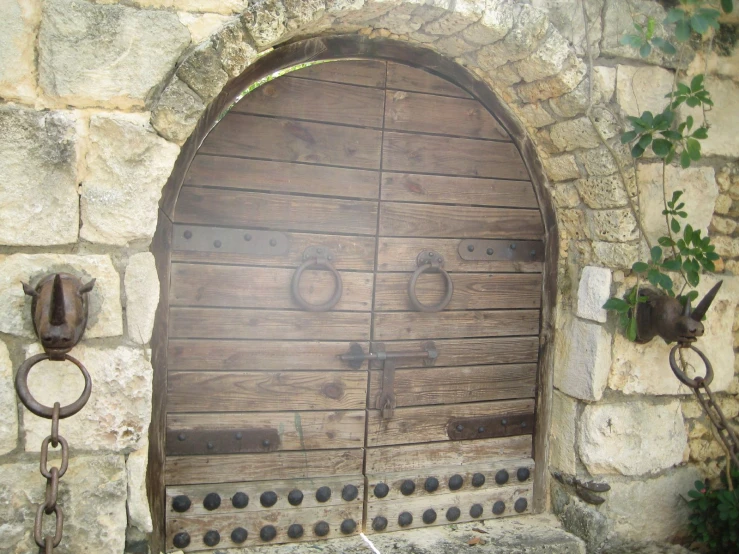 an old, large wooden door and chain hang on the wall