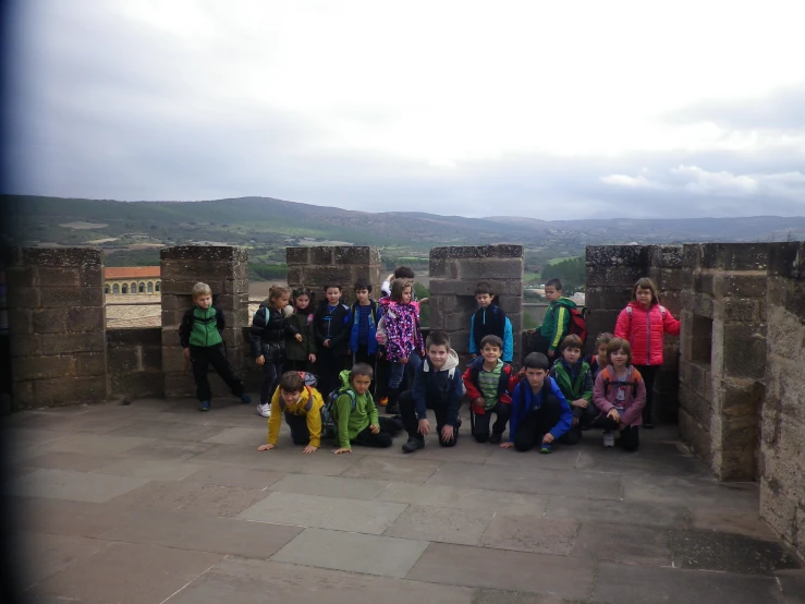 group of children standing in front of a wall