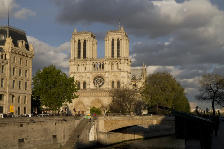 a large cathedral near some water in front of trees