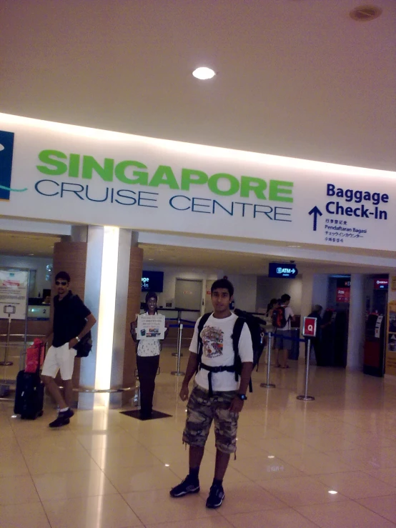 a man with luggage standing in front of singapore cruise center