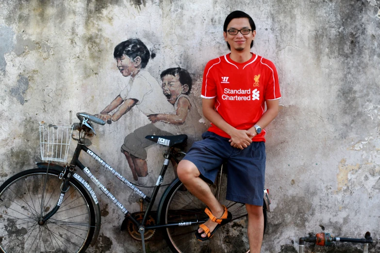 a man is standing next to a bicycle that has a picture of two s on it