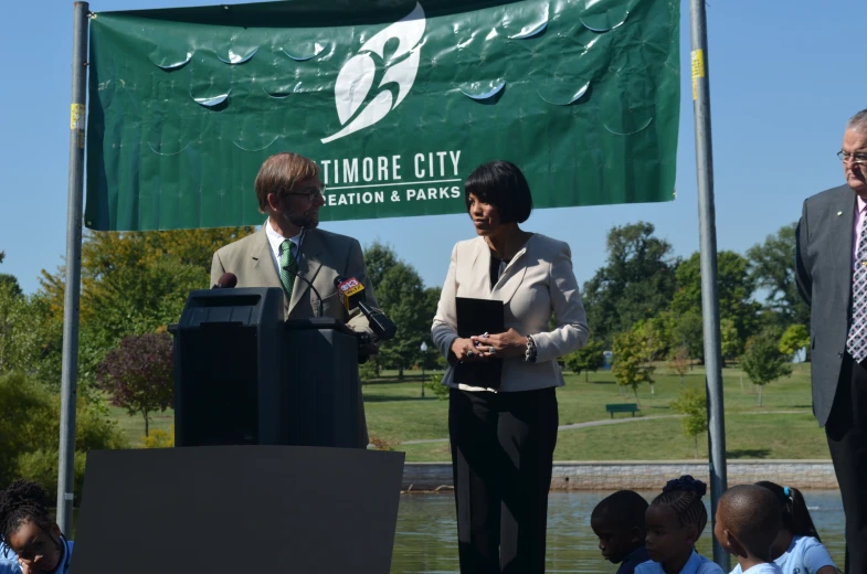 two men and a women are standing at a podium