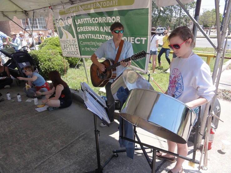 two people playing instruments under a tent