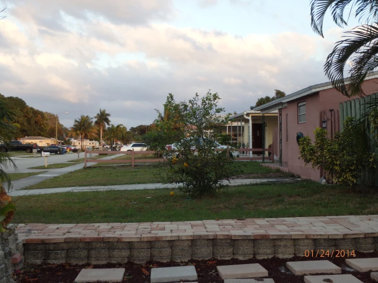 a small pink house is in a grassy yard