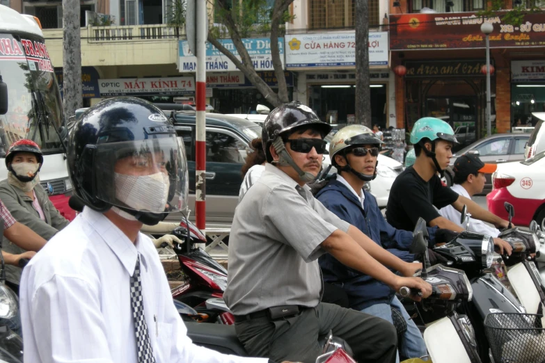 a group of people with helmets on motor scooters