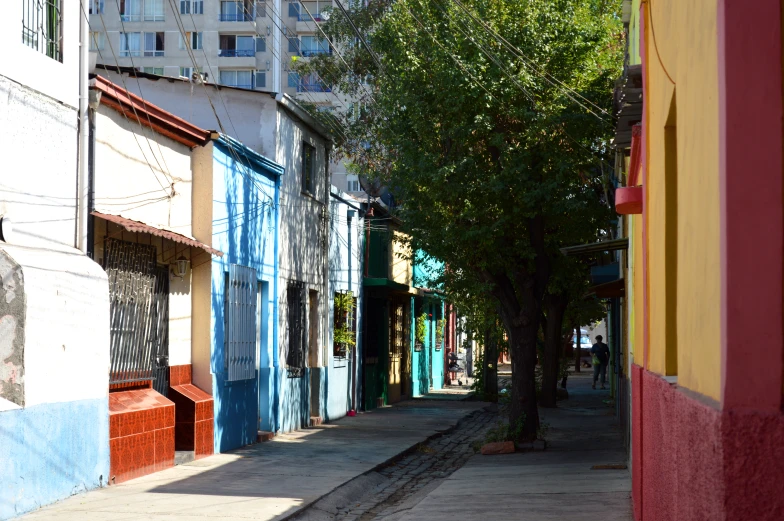 an empty street and sidewalk with brightly colored buildings