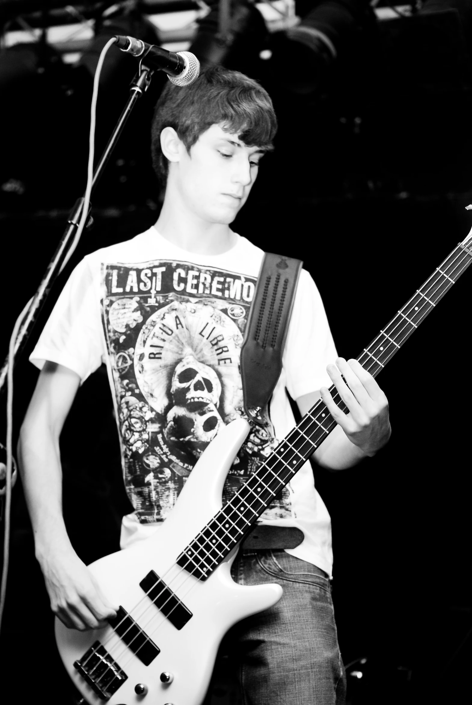 a young man in a white t - shirt playing guitar