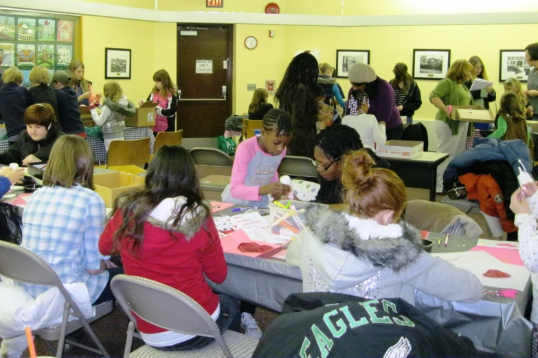 a group of girls sitting around tables in a room