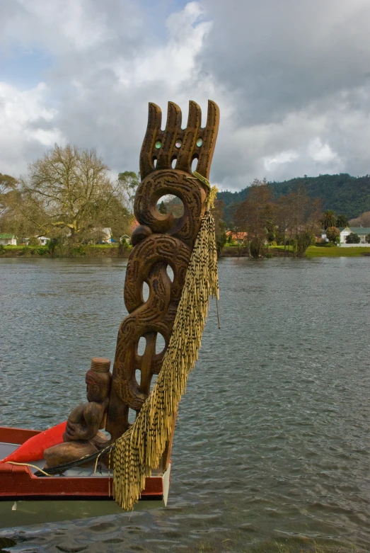 a large wooden sculpture on the side of a body of water