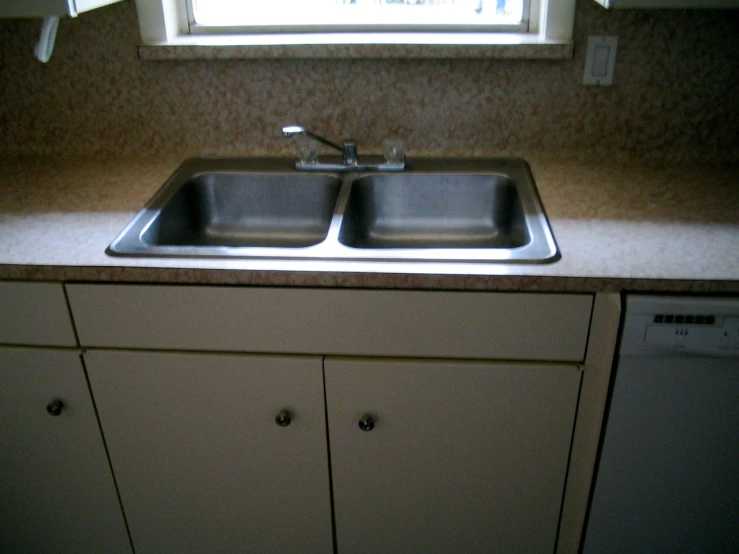 a kitchen sink with two matching dishes in the middle of it