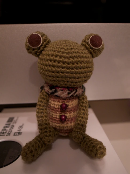 a crocheted stuffed animal with glasses and a scarf