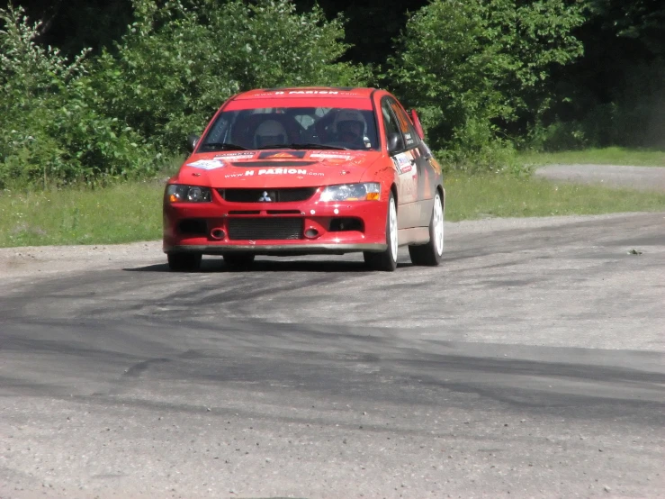 a red car making a sharp turn on a track