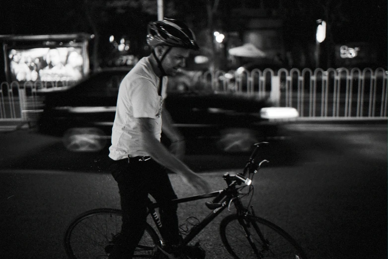 a man riding a bike down a street at night