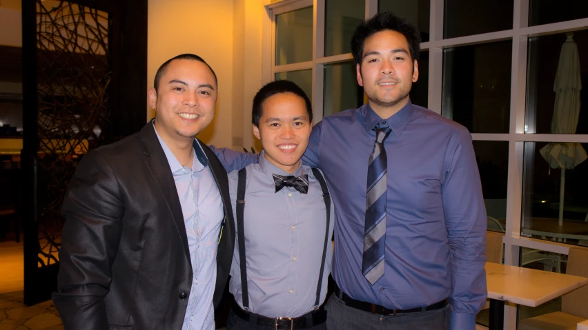 three males posing for a picture in a room