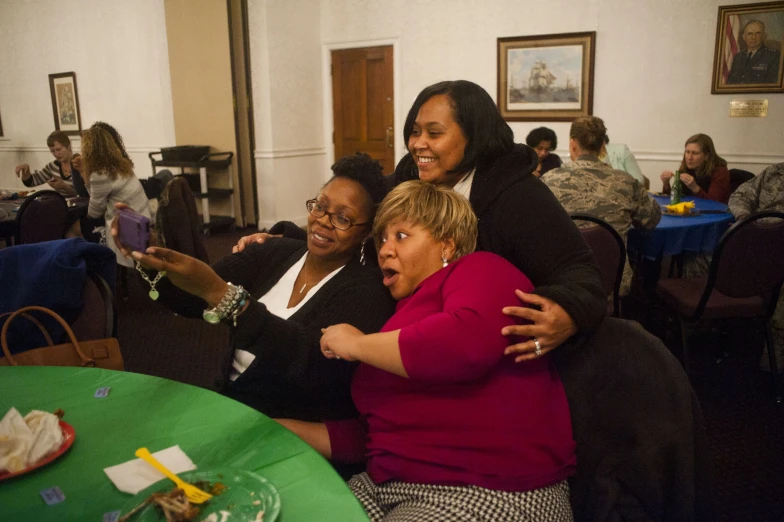 three women are taking selfies at the restaurant