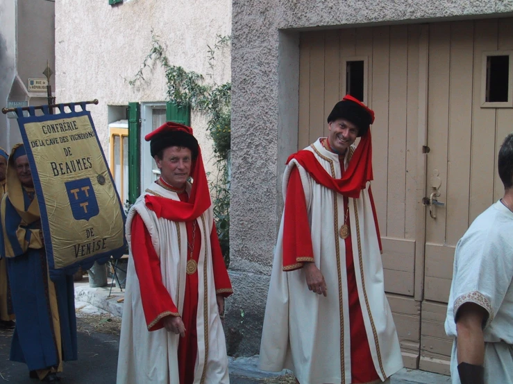 two men in priest robes and hats, one wearing an adult's cloak