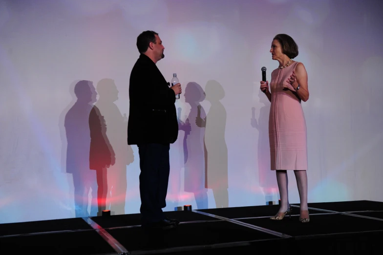 a woman standing on a stage holding a microphone