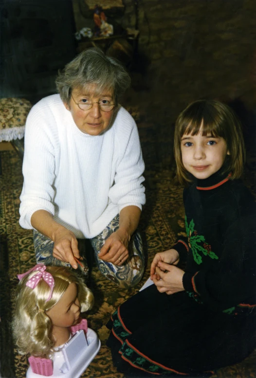 two children sitting down near an old woman