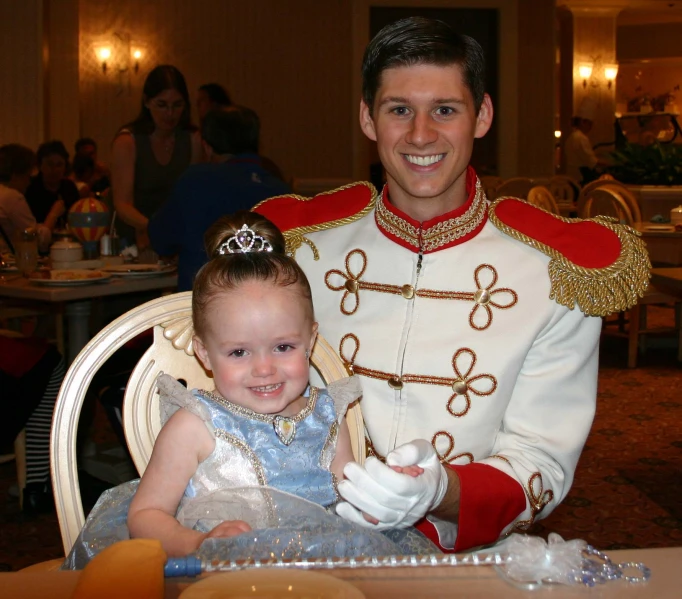 a man in a uniform sitting at a table with a child