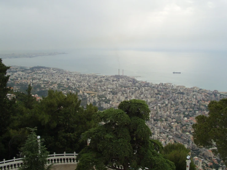 a city sitting over looking some water and trees