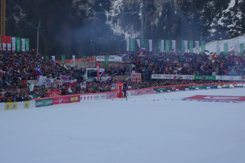 a snow covered slope filled with lots of people