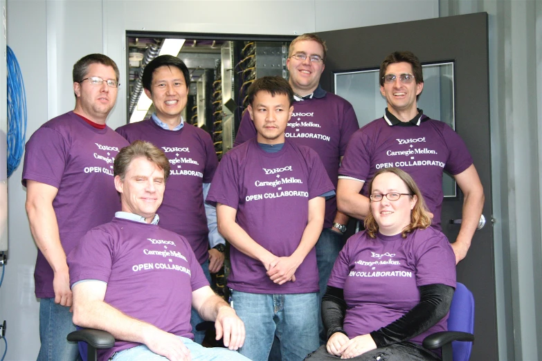 a group of men standing and sitting next to each other