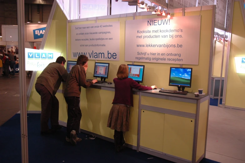 people using computers on display at an electronic expo